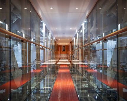 The Engine Room walkway at Fingal with red floor, glass walls and the machinery either side.