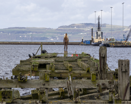 A sculpture of a man at the end of an abandoned pier in Leith.
