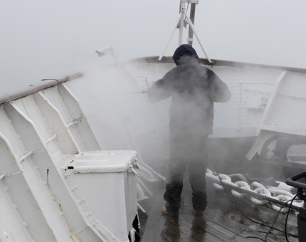 A man washing down the Fo'c'sle Deck.