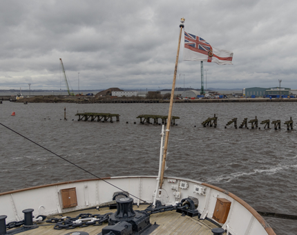 The stern of Britannia with a flag flying.