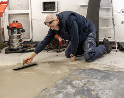 A man from Maintenance screeding the deck.