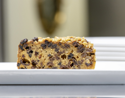 A slice of Dundee cake on a plate.