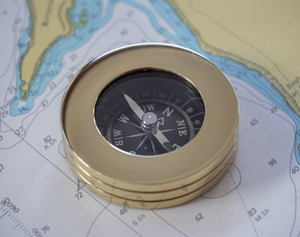 A compass sitting on a map. 