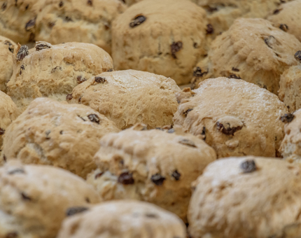 A tray of lots of fruit-filled scones. 