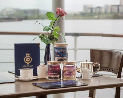 A table in the Royal Deck Tearoom laid with teapot, cup and saucer, menu and three jars of tea. 