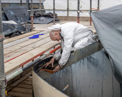 The Maintenance team member placing a drainage grill on top of the Funnel.