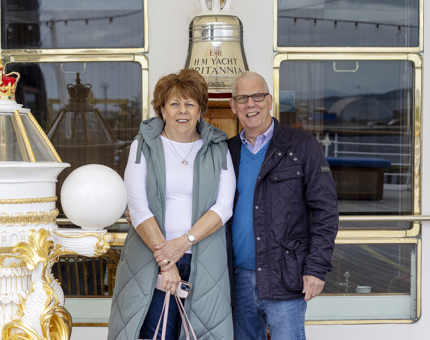 A couple standing next to the compass binnacle at The Royal Yacht Britannia. 