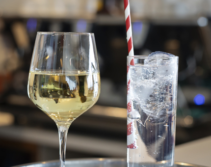 A glass of white wine and a gin and tonic.