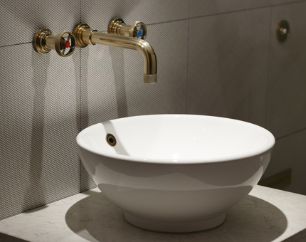 A wide, round basin and nautical-inspired brass tap in a bathroom at Fingal.