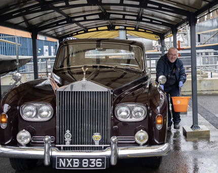 A man from the Facilities team polishing the Rolls-Royce car.