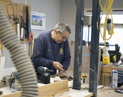 Maintenance team member in the workshop with a door from Bloodhound.