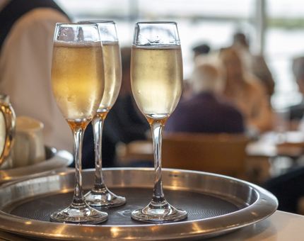 Three glasses of Sparkling Rosé on a tray in the Royal Deck Tearoom. 