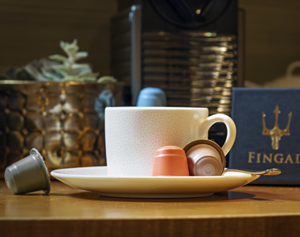 A coffee cup and saucer with coffee pods in a cabin at Fingal. 