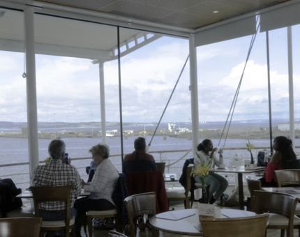 A wide view of the Royal Deck Tearoom with floor to ceiling windows. 