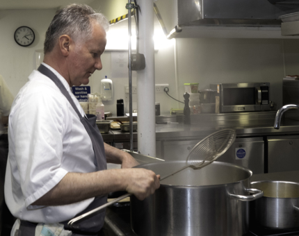 A Chef is preparing dinner in the Galley.