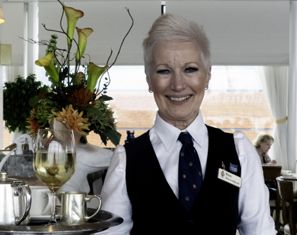 A woman holding a tray in the Tearoom. 