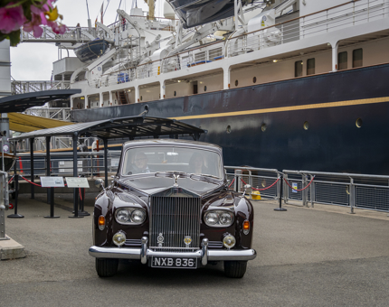 A burgundy Rolls-Royce on the quayside next to Britannia. 