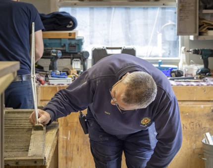 A man is working in the Maintenance workshop. 