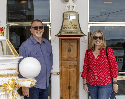 Two visitors stand beside the Bell aboard The Royal Yacht Britannia.