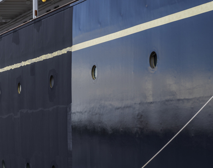 The hull painting is seen in progress. The undercoat on the left section and the finished panel is on the right.