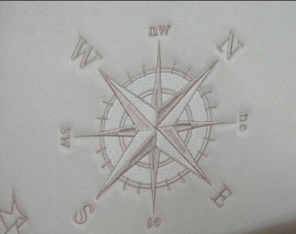 Detail of a compass on a headboard.