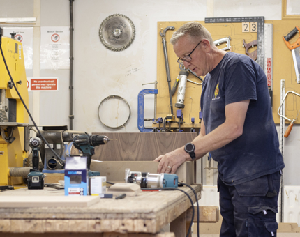 A man in a workshop making a drawer