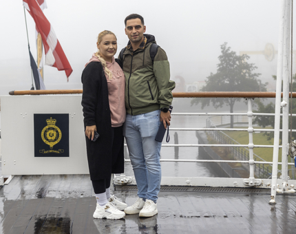 A man and a woman pose for a photo on the Verandah Deck. 