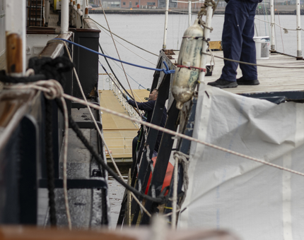 Two men on the Paint Cat painting the Starboard side of the ship. 