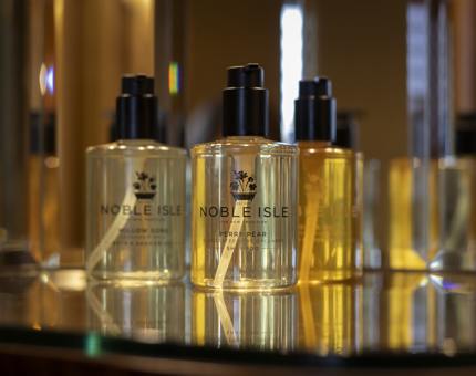 Three bottles of Noble Isle bath and body products.
