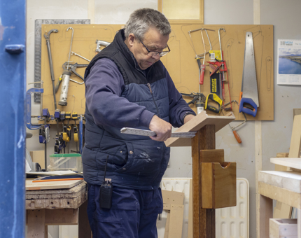A man in the maintenance workshop making a menu stand.