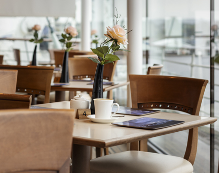 Tables set with vases of flowers in the Tearoom. 