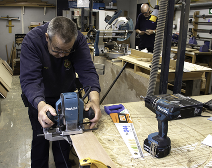 Maintenance team member in the workshop prepares a stand for a shield.