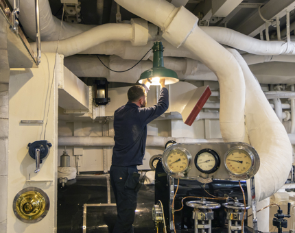 In the Engine Room, a man changes a lightbulb.