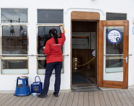 A Housekeeper polishing the outside of the Sun Lounge.