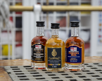 Three miniature bottles of rum and whisky. 