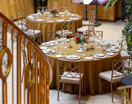 A view down the staircase to round set table in the Ballroom.