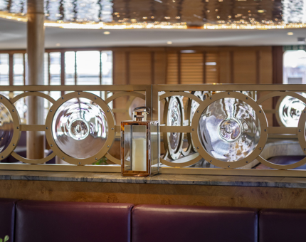 Details of round glass and brass fixtures and a shimmering ceiling in The Lighthouse Restaurant & Bar.
