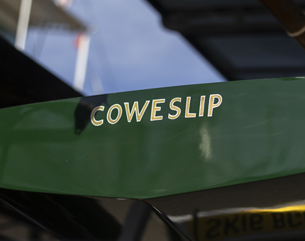 A close-up of Coweslip, a small green sailing yacht. 