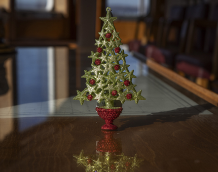 A Christmas tree decoration in the shape of a red and green tree made up of stars.