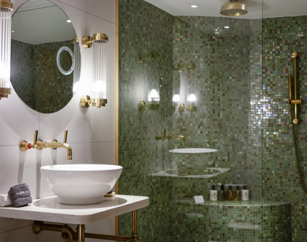 A bathroom inside a cabin at Fingal. The walls are green mosaic. 