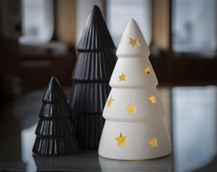 Two black and one white ceramic Christmas tree ornaments.