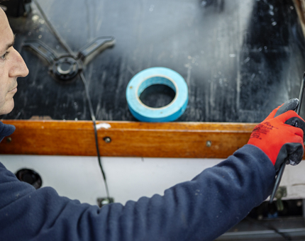 A member of the Maintenance team painting the Admiral's Fast Motor Launch.