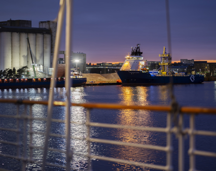 A view over the Port of Leith from the Verandah Deck at sunset. There is a ship docked in the background.