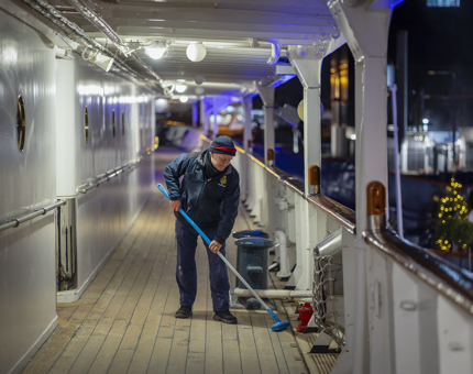 A Maintenance team member sweeping the deck.