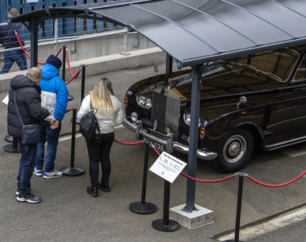 Visitors looking at the Rolls-Royce car that is on display. 