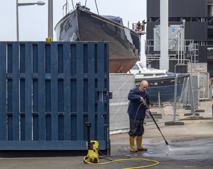 A man is power washing the Quayside. 
