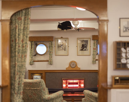 A view of the Wardroom sitting area with a fan on the roof with a stuffed toy wombat on it. 