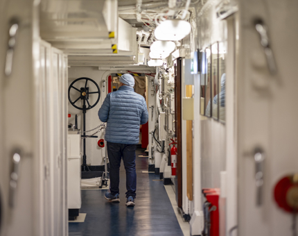 Visitors walking down a corridor in the Crew's Quarters. 