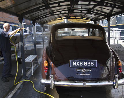 The Rolls-Royce car is hosed down. 