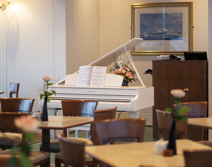 A white grand piano in the Tearoom.